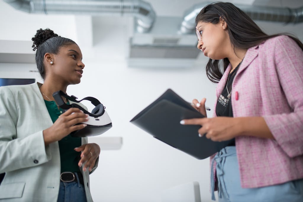 Two diverse young professionals engaged in a discussion about virtual reality technology in a modern office.